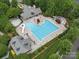 Aerial view showcasing a large community pool, kiddie pool, and surrounding green spaces at 1061 Woodglen Ln, Matthews, NC 28104