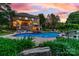 Beautiful backyard with a sparkling pool, jacuzzi, outdoor seating and a brick house with a screened porch at 1115 Maremont Ct, Matthews, NC 28104