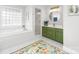 Bathroom features a tub, walk-in shower, green vanity and floral rug at 1115 Maremont Ct, Matthews, NC 28104