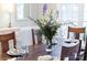 Close-up on dining table with floral centerpiece and place settings at 1115 Maremont Ct, Matthews, NC 28104