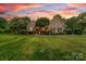 Charming brick home with lush lawn, manicured landscaping, and inviting curb appeal at sunset at 1115 Maremont Ct, Matthews, NC 28104
