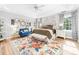 Bright main bedroom with hardwood floors, a colorful rug and sitting area at 1115 Maremont Ct, Matthews, NC 28104