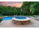 An inviting backyard features a sparkling pool and jacuzzi surrounded by lush greenery and chairs at 1115 Maremont Ct, Matthews, NC 28104