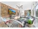 Inviting screened porch with brick wall, comfortable seating, ceiling fan, and mounted television at 1115 Maremont Ct, Matthews, NC 28104