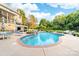 Beautiful backyard with a large swimming pool, hot tub, lounge chairs, and mature trees at 1115 Maremont Ct, Matthews, NC 28104