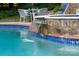 Close-up view of a pool with a waterfall feature, showing the beautiful water and landscaping at 1115 Maremont Ct, Matthews, NC 28104