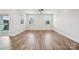 Large, empty living room with hardwood floors, ceiling fan, and natural light from the windows and sliding glass door at 1213 Margo Mannor Dr, Fort Mill, SC 29708