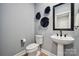 Chic powder room with a pedestal sink, sleek fixtures, and modern wall decor at 1213 Margo Mannor Dr, Fort Mill, SC 29708