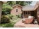 Brick patio with lounge seating, lush landscaping, and the back exterior of home at 1226 Tarrington Ave, Charlotte, NC 28205