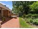Brick patio with lounge seating next to the lush backyard and garden at 1226 Tarrington Ave, Charlotte, NC 28205