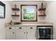 Stylish bar area featuring a countertop, cabinets, floating shelves, and a wine cooler at 1226 Tarrington Ave, Charlotte, NC 28205