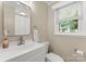 Well-lit bathroom with white vanity, modern fixtures, and a window offering outdoor views at 1226 Tarrington Ave, Charlotte, NC 28205