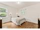 Cozy bedroom with hardwood floors, a queen-sized bed, and natural light from two windows at 1226 Tarrington Ave, Charlotte, NC 28205