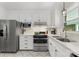 Bright kitchen featuring white cabinets, stainless steel appliances, and modern fixtures at 1226 Tarrington Ave, Charlotte, NC 28205