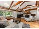 Cozy living room with beamed ceilings, a brick fireplace, hardwood floors, and ample natural light at 1226 Tarrington Ave, Charlotte, NC 28205