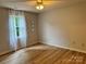Bright bedroom with a window with sheer curtains, wood-look floors, and three decorative mirrors at 1228 Hidden Creek Cir, Hickory, NC 28602