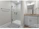 This bathroom features a stand up shower, gray tile, and a single sink vanity with brushed brass fixtures at 1280 Winged Foot Dr, Denver, NC 28037