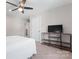 Bright bedroom features a ceiling fan, closet and modern console table with a television at 1280 Winged Foot Dr, Denver, NC 28037