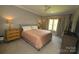 Comfortable bedroom with neutral decor, featuring a large bed, ceiling fan, and window treatments at 1280 Winged Foot Dr, Denver, NC 28037