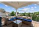 Relax on this covered deck with wicker seating and table with neighborhood and tree views at 1280 Winged Foot Dr, Denver, NC 28037