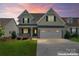 Charming two-story home features a brick-accented front porch, attached two-car garage, and manicured lawn at 1280 Winged Foot Dr, Denver, NC 28037