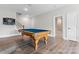 Spacious game room features a pool table, stairs, and a doorway to a bathroom with modern fixtures at 1280 Winged Foot Dr, Denver, NC 28037