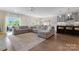 Open-concept living room featuring a large sectional sofa, hardwood floors, and a view of the backyard at 1280 Winged Foot Dr, Denver, NC 28037