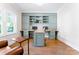 Bright office space featuring custom-built-in shelving, cabinets, hardwood floors, and a comfortable seating area at 1280 Winged Foot Dr, Denver, NC 28037
