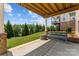 A covered patio with a bench overlooks a lush green lawn and trees beyond at 1280 Winged Foot Dr, Denver, NC 28037