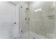 Bathroom featuring a frameless glass shower enclosure with a rain shower head and tiled walls at 1280 Winged Foot Dr, Denver, NC 28037
