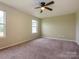 Spacious carpeted bedroom with a ceiling fan and natural light from two windows at 13022 Hill Pine Rd, Midland, NC 28107