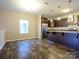 Open-concept kitchen and dining area with dark wood cabinets, stainless steel appliances, and stylish laminate flooring at 13022 Hill Pine Rd, Midland, NC 28107