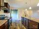 Kitchen featuring stainless steel appliances, wooden cabinetry, and a view of the dining and staircase at 13022 Hill Pine Rd, Midland, NC 28107