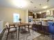 Modern kitchen and dining space featuring dark cabinets, bar seating, and laminate flooring, staged with dining set at 13022 Hill Pine Rd, Midland, NC 28107