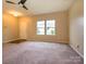 Bright living room with neutral carpet, natural light, and access to other rooms creates a cozy, airy atmosphere at 13022 Hill Pine Rd, Midland, NC 28107