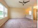 Spacious living room with carpet, large windows offering plenty of natural light, and a ceiling fan at 13022 Hill Pine Rd, Midland, NC 28107