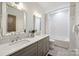 Stylish bathroom with double vanity, large mirrors, and tub with shower at 1315 Charles Ave, Charlotte, NC 28205