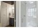 Bright bathroom featuring white subway tile shower, dark vanity, and paneled walls at 1315 Charles Ave, Charlotte, NC 28205