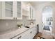 Charming butler's pantry with marble counters, glass cabinets, wine cooler, and white decor at 1315 Charles Ave, Charlotte, NC 28205