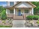 Inviting front porch with wooden railings, brick accents, and manicured landscaping leading to a bright blue front door at 1315 Charles Ave, Charlotte, NC 28205