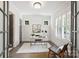 Well-lit home office with white desk, plantation shutters, and a comfortable woven chair at 1315 Charles Ave, Charlotte, NC 28205