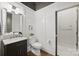 Stylish powder room with dark vanity, marble countertop, wainscoting and a decorative mirror at 1315 Charles Ave, Charlotte, NC 28205