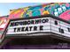 Neighborhood Theatre with retro-style lettering on a building with colorful artwork at 1315 Charles Ave, Charlotte, NC 28205