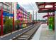 Modern light rail station with colorful mural on nearby building. Sign reads: 36th Street at 1315 Charles Ave, Charlotte, NC 28205
