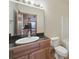 Bathroom with wood cabinets, an elongated toilet, and a large framed mirror at 1340 Canter Ln, York, SC 29745