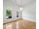 Bright dining room featuring hardwood floors, elegant chandelier, and abundant natural light from two large windows at 1340 Canter Ln, York, SC 29745