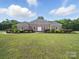 Charming brick home featuring a meticulously landscaped front yard with lush green grass and manicured bushes at 1340 Canter Ln, York, SC 29745