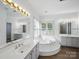 Luxurious main bathroom featuring a jacuzzi tub, double vanities, and ample natural light at 1340 Canter Ln, York, SC 29745