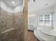 Well-lit main bathroom with tiled shower, jacuzzi tub and large windows at 1340 Canter Ln, York, SC 29745
