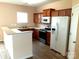 Functional kitchen with white appliances, warm wood cabinetry, and breakfast bar at 13441 Calloway Glen Dr, Charlotte, NC 28273